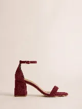 Sandalia de tacón bajo cuadrado con diseño minimalista, confeccionada en tela resistente con acabado aterciopelado. Presenta una tira delgada en la parte frontal y una pulsera ajustable con hebilla metálica en el tobillo.