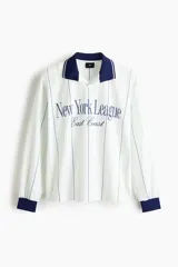Camiseta de fútbol de manga larga H&M en malla estampada, color blanco con rayas verticales y cuello y puños en azul marino. Cuenta con diseño holgado y estampado frontal "New York League East Coast".