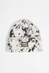 Gorro tipo beanie de punto con diseño estampado estilo animal print de lince en tonos blanco y negro. Presenta un parche rectangular con el logo de la marca en el frente.