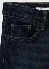 Jeans de tiro medio con corte flare y bajo deshilachado. Presentan diseño de cinco bolsillos, cierre frontal con cremallera y botón, y trabillas para cinturón.
