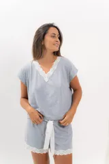 Pijama celeste de algodón con textura acanalada, compuesto por una remera de mangas cortas con escote en V y puntilla blanca, y un short con elástico en la cintura, lazo y terminación con puntilla.
