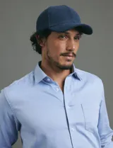 Camisa de vestir de manga larga en color azul claro, con cuello clásico, cierre frontal de botones y bolsillo en el pecho.