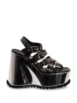 Sandalias negras de cuero con plataforma plateada y tiras con hebillas.