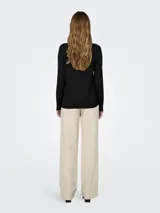 Suéter de punto fino color negro, con cuello redondo y mangas largas que terminan en puños con abertura y botones decorativos.