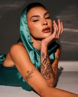 Minivestido satinado color verde esmeralda, con capucha, espalda descubierta y drapeado en la falda.