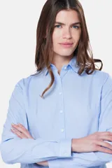 Camisa celeste a rayas verticales, de corte entallado y manga larga.