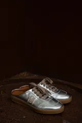 Zuecos plateados con cordones marrones y suela color caramelo.