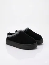 Zueco de gamuza color negro con interior forrado en piel sintética, suela de plataforma y detalle de bordado geométrico en el borde superior.