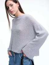 Sweater de punto negro con lentejuelas sutiles, de corte holgado, hombros caídos y mangas largas con terminación acampanada.