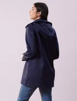 Gabardina color beige, impermeable, con abertura central con botones, bolsillos delanteros, capucha desmontable y forro interno.