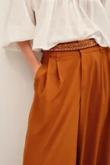 Pantalón ancho negro de tiro medio, con bolsillos laterales y pinzas frontales.