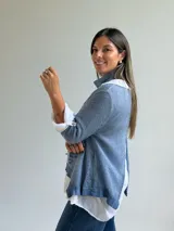 Sweater de punto color celeste con diseño asimétrico y detalle de encaje en el frente, acompañado por un pañuelo a juego.