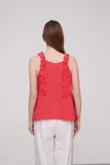 Musculosa roja de algodón con breteles finos, volados en los breteles y frunces en el frente.