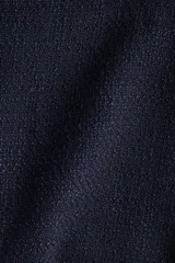 Vestido corto de bouclé color azul marino, con escote redondo, manga francesa, falda con vuelo y detalles de bolsillos decorativos con botones dorados.
