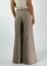 Pantalón de lino azul de corte palazzo, tiro alto y pierna ancha. Presenta costuras a la vista en color blanco y botón metálico.