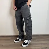 Jean cargo de corte baggy, color gris lavado, con múltiples bolsillos laterales y cierre frontal.