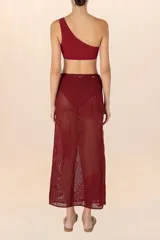 Falda pareo larga color vino, de tejido calado con bordado floral y detalle de cuentas en los pliegues.