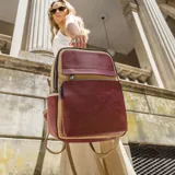 Mochila combinada color verde militar y mostaza, con doble bolsillo frontal y cierre de cremallera. Tiene asa de mano y correas regulables.