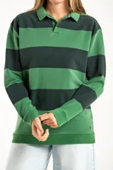Sweater de punto con diseño de rayas horizontales anchas en tonos verde oscuro y verde claro, con cuello tipo polo y cierre frontal parcial. Presenta mangas largas con puños elásticos y un pequeño bordado en la parte inferior.