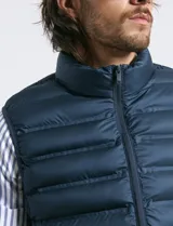 Chaleco acolchado de diseño capitoneado con cierre frontal al tono, cuello alto y ribetes en sisas y ruedo.