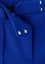 Pantalón de tiro medio color azul, con diseño recto y largo, trabillas para cinturón y cierre oculto con botón, gancho y cremallera.