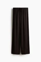 Pantalón marrón oscuro de corte holgado y piernas amplias, con cintura elástica fruncida y cordón ajustable.