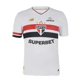 Camiseta de fútbol New Balance del São Paulo FC, modelo Home 2025. Diseño blanco con franjas horizontales rojas y negras en el pecho, detalles en rojo y negro en el cuello y las mangas, y logos de New Balance y sponsors.