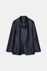 Blazer entallada de Zara Woman Collection, color azul marino, con cuello subido y detalle de tejido a contraste. Presenta cierre frontal cruzado con botones, manga larga y bolsillos con solapa en el delantero. Incluye forro interior.