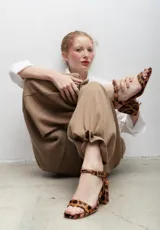 Pantalón de vestir azul eléctrico con pinzas, tiro alto, corte ancho y cinturón marrón con hebilla metálica con forma de sol.