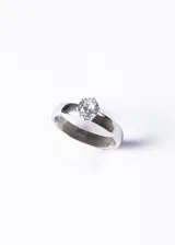 Anillo plateado de acero quirúrgico con cintillo ancho y piedra strass engarzada.