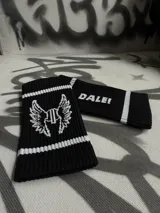 Par de muñequeras deportivas negras con rayas blancas y texto estampado.