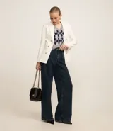 Blazer femenino de sastrería confeccionado en punto roma, con cuello solapa, cierre frontal con botones decorativos y diseño estructurado.