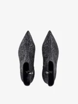 Bota corta de caña baja con acabado de glitter negro, punta fina y tacón cuadrado.