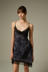 Vestido mini color gris con estampado floral en terciopelo negro, tirantes finos, escote en V y detalles de encaje negro en el escote y el ruedo.