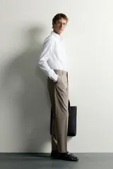 Camisa de corte slim fit, color celeste, con cuello italiano y manga larga con puños abotonados. Presenta un tejido con textura y cierre frontal de botones.