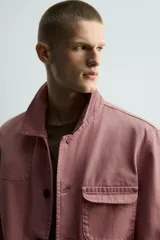 Cazadora de corte relajado confeccionada en algodón con efecto lavado. Presenta cuello solapa, cierre frontal con botones, mangas largas y múltiples bolsillos de plastrón con solapa en el delantero.