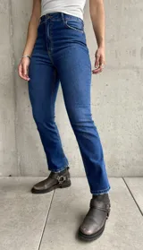 Jean de calce recto con lycra, color azul medio, con bolsillos delanteros y traseros.