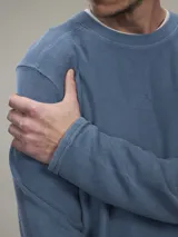 Buzo de tejido polar (fleece) color azul piedra, con cuello redondo y manga larga.