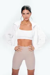 Campera blanca con capucha y ajustes en cintura y cuello.