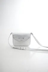 Bandolera compacta de cuero vacuno color gris con efecto gastado, solapa redondeada y correa ajustable.