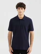 Chomba de piqué color azul oscuro, con cuello clásico, cierre frontal de dos botones y mangas cortas con terminación en rib.