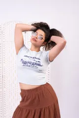 Remera baby tee celeste con estampa frontal inspirada en un tren y texto "Strive to be better Boston", de corte ajustado y mangas cortas.