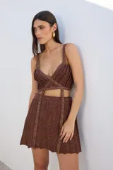 Top negro de lurex con tiras finas, escote en V y diseño cruzado en el abdomen.