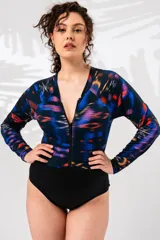 Malla entera de lycra con estampado abstracto en tonos azules, naranjas y violetas. Tiene cierre frontal con cremallera y mangas largas.
