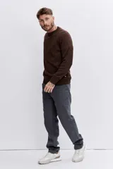 Sweater de punto de cuello redondo, con diseño jaspeado en tono marrón oscuro, de corte clásico y mangas largas con puños acanalados.