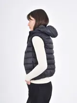 Chaleco puffer corto de color blanco, con cuello alto, cierre frontal y diseño acolchado.