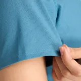 Remera deportiva azul de corte ajustado, con mangas cortas y logo de New Balance estampado en el pecho.