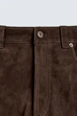 Pantalón de corte straight fit confeccionado en ante de color marrón, con diseño de cinco bolsillos y cierre frontal con cremallera y botón.
