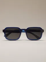 Gafas de sol rectangulares de montura gruesa, color azul brillante, con lentes oscuros.