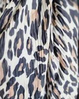 Chalina rectangular de tela plisada con estampado animal print de leopardo en tonos blanco, negro y marrón.